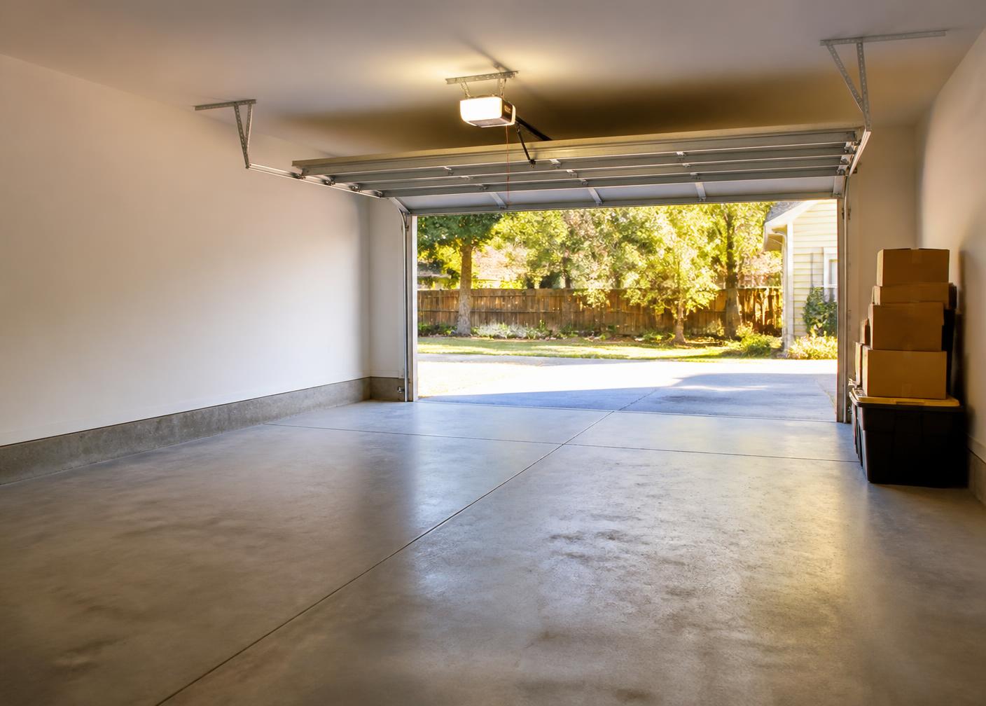 Empty swept garage after a professional cleanout with boxes stacked by the door